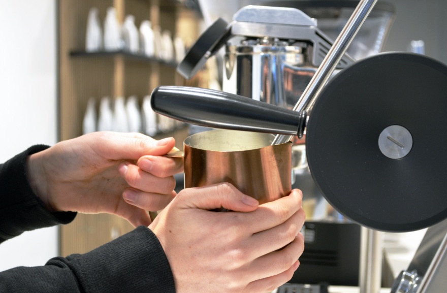 Koffiebar Amsterdam, Barista die een koffie schenkt met een koffieapparaat van de koffiezaak Cafecito